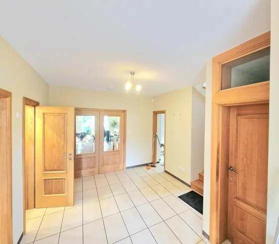Hallway with oak doors, cream walls and a tiled floor
